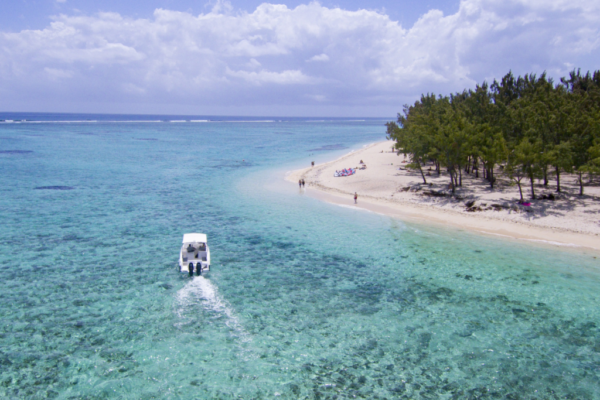 Vue aérienne d'un bateau approchant un banc de sable et d'une plage bordée de filaos à l'île Maurice
