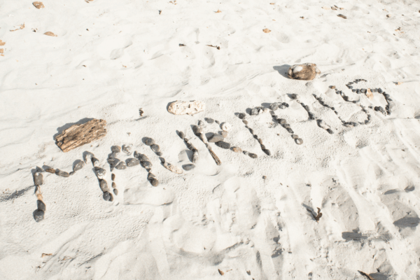 Le mot Mauritius écrit avec des galets sur le sable blanc d'une plage