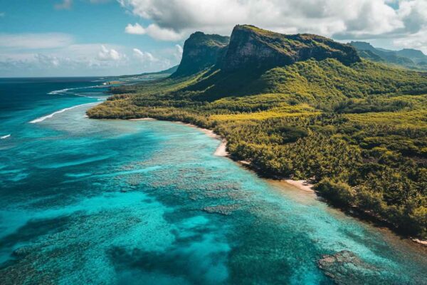 Vue aérienne d'une côte de l'île Maurice avec falaise verdoyante, récif et lagon turquoise