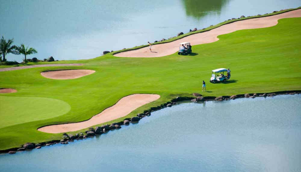Parcours de golf tropical bordé de plans d'eau et de bunkers de sable à l'île Maurice