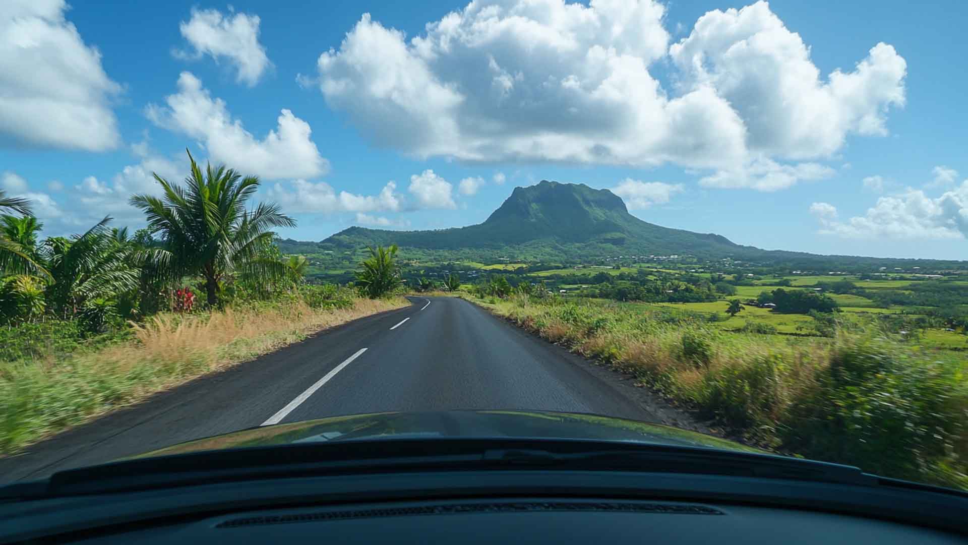 Route de campagne à l'intérieur des terres de l'île Maurice, vue depuis un pare-brise, montagne en arrière-plan