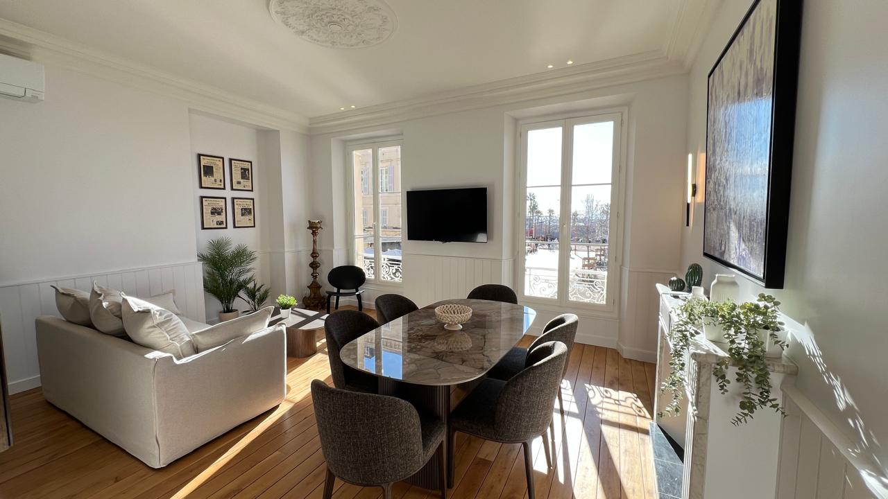 Salon lumineux des bureaux Romuald Rousseaux à Cannes, fenêtres ouvertes sur la Croisette